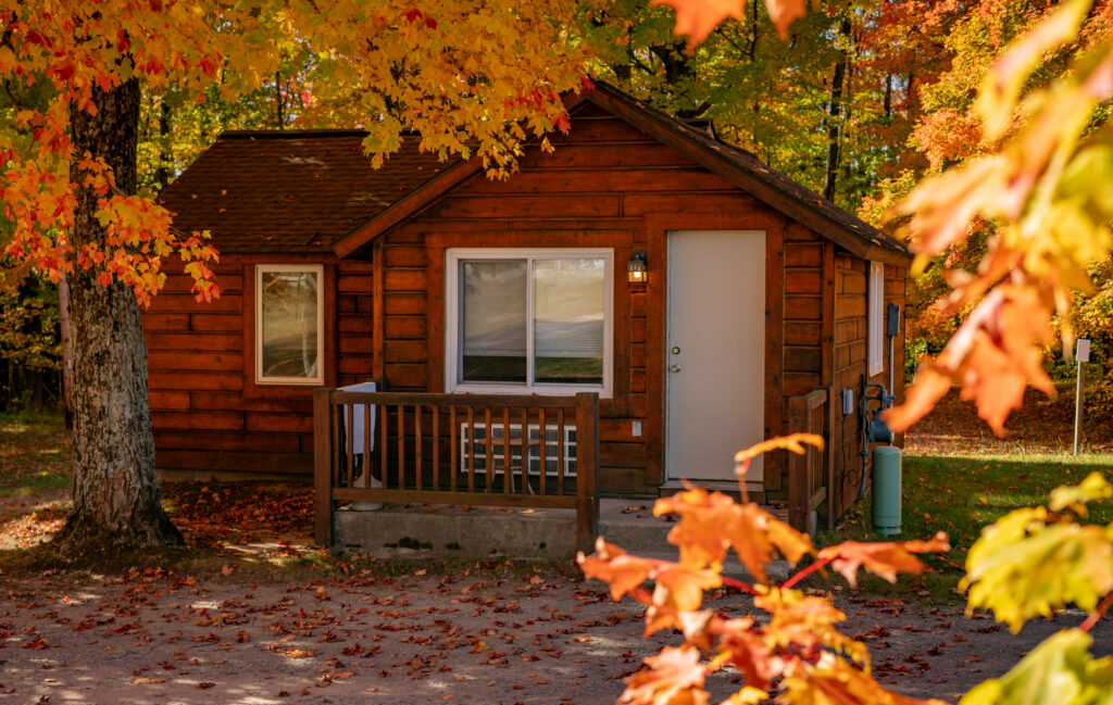 A beautiful log cabin in autumn surrounded by hardwood trees in Munising, Michigan.