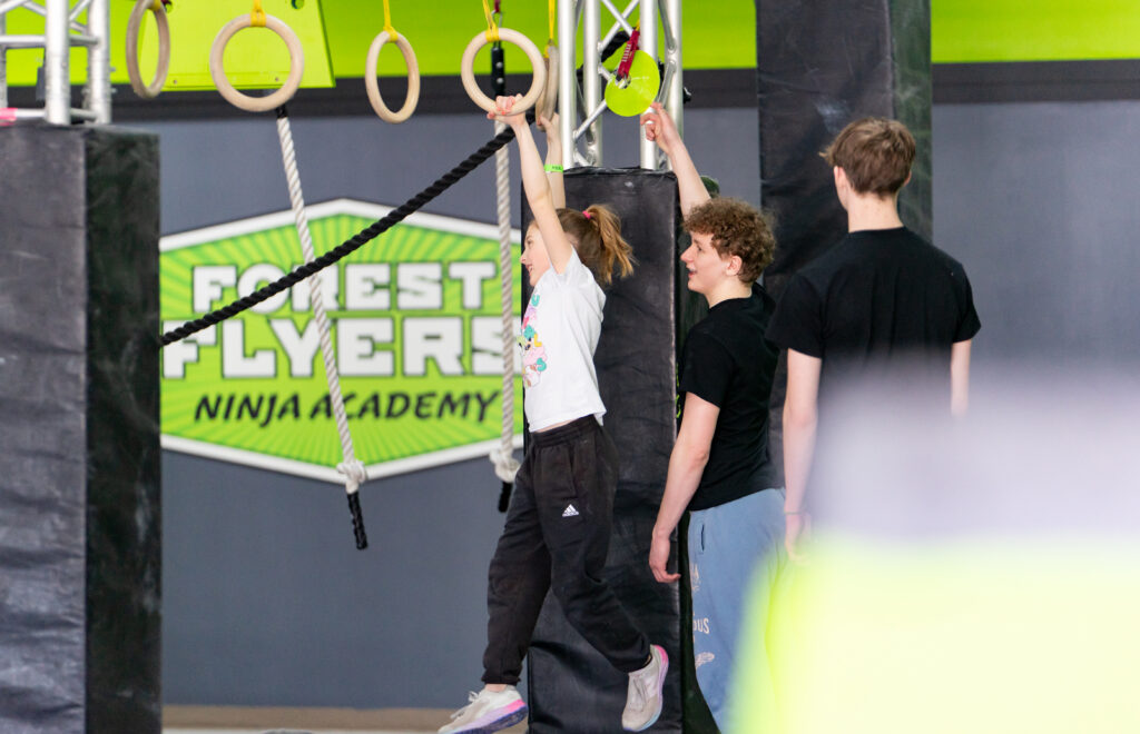 A young girl having fun at Forest Flyers Ninja Academy in Negaunee, Michigan.