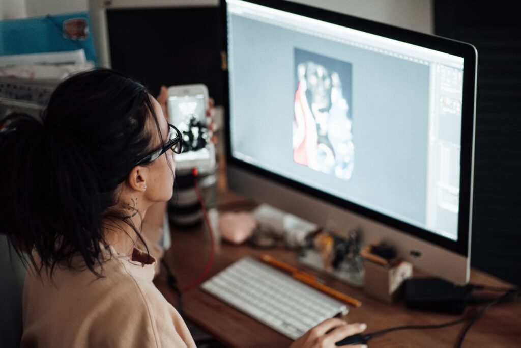 A young women who is a graphic designer in the Upper Peninsula works on a design on here Mac computer.